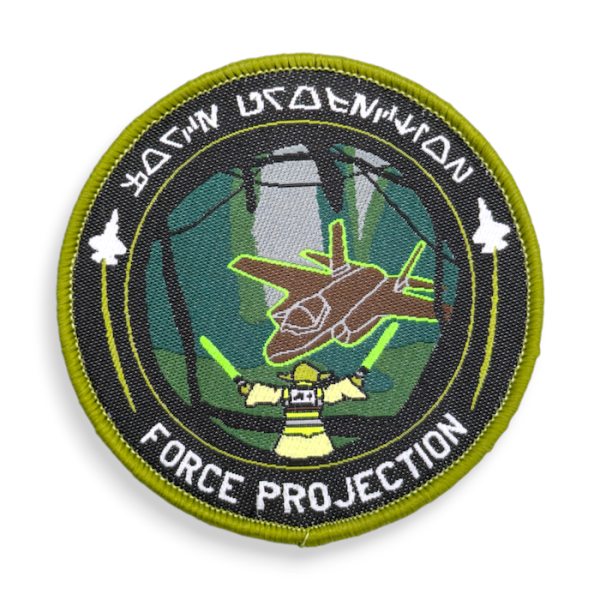 A circular woven patch that shows Yoda using light sabres bringing in a aircraft.